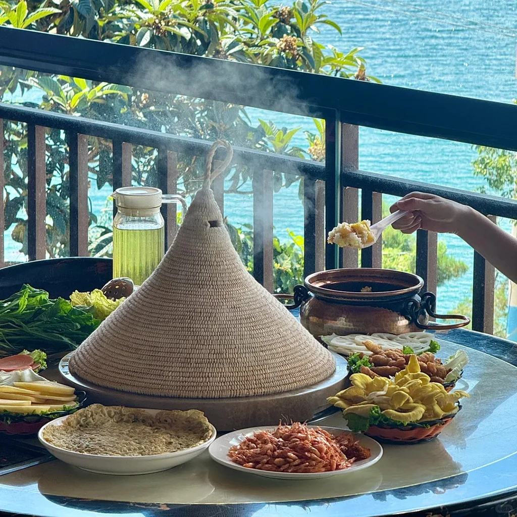 道地瀘沽湖石鍋魚,雲南湖畔特色料理。新鮮魚類以手工雕刻石鍋蒸製,覆蓋編織草蓋,搭配新鮮配菜與絕美湖景。