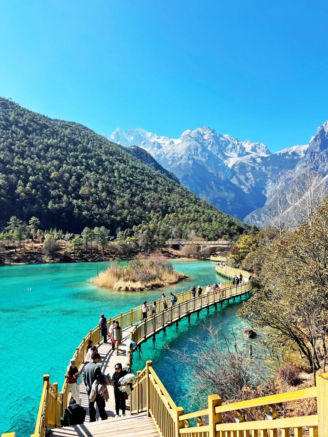 麗江玉龍雪山藍月谷,木棧道延伸於藍綠色湖水之上,搭配山景風光。