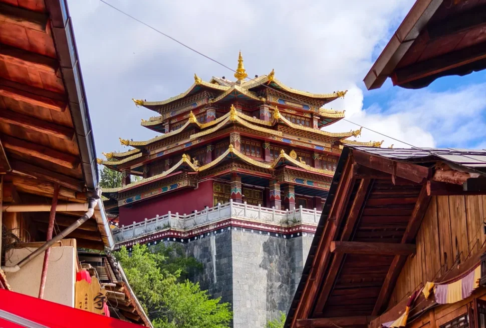 香格里拉獨克宗古城大佛寺，金頂層疊藏式古殿雄偉莊嚴，聳立高原山巔，夾在原木藏式民居古巷之間，滿載千年藏傳佛教聖地風韻。