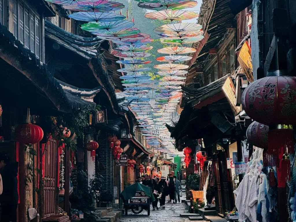 雲南麗江古城油傘街,五彩油傘鋪滿歷史石板巷,兩側是傳統納西建築與紅燈籠,遊客絡繹不絕。