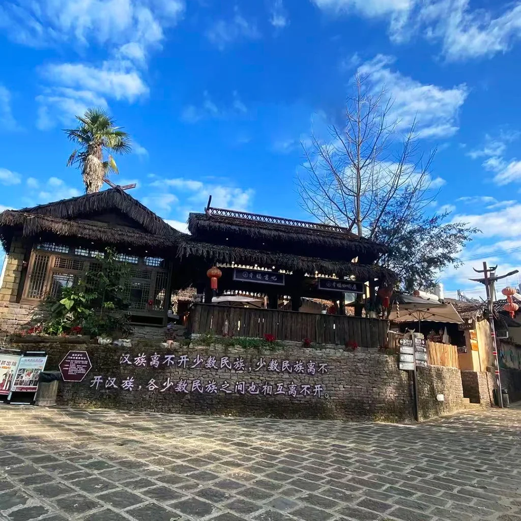 騰衝司莫拉佤族村的傳統茅草屋,青石板路、紅燈籠與藍天相映,是保存完好的佤族原生態古村落。