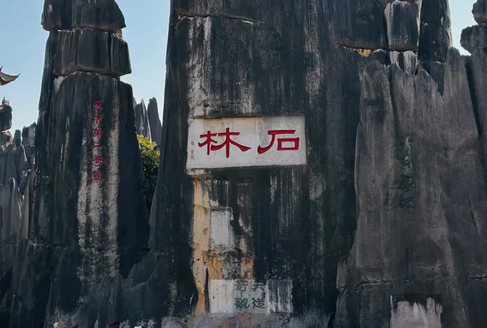 昆明石林風景區的核心地標，刻有「石林」字樣的巨型喀斯特石柱，旁邊還有「天下第一奇觀」的經典題字，是雲南必訪的世界自然遺產景點。