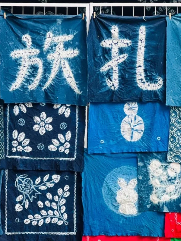 大理白族扎染工藝,藍染布料呈現傳統圖案與漢字,展現民族特色。
