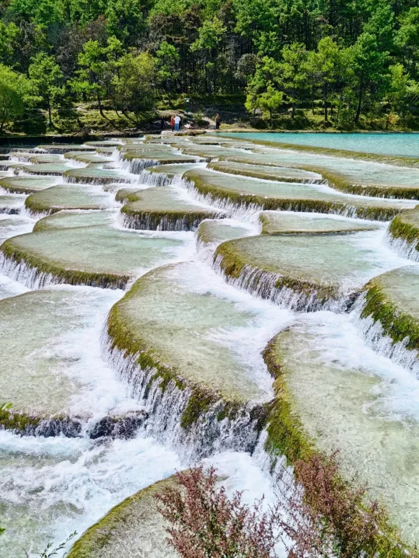 藍月谷水流沿石灰岩層層流動,形成獨特的階梯水台景觀。