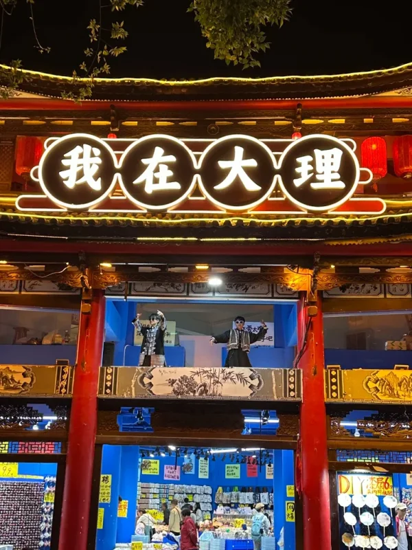 大理古城夜晚街景,傳統建築與燈光招牌交織,呈現熱鬧氛圍。