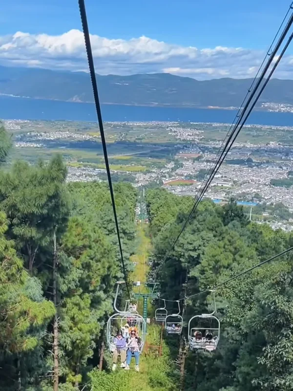 大理蒼山索道景觀,遊客搭乘纜車穿越森林山坡,俯瞰洱海與城市風光。