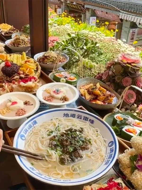 大理美食展示,包含雲南特色麵食、米飯料理與多樣在地佳餚,擺放於窗邊餐桌。