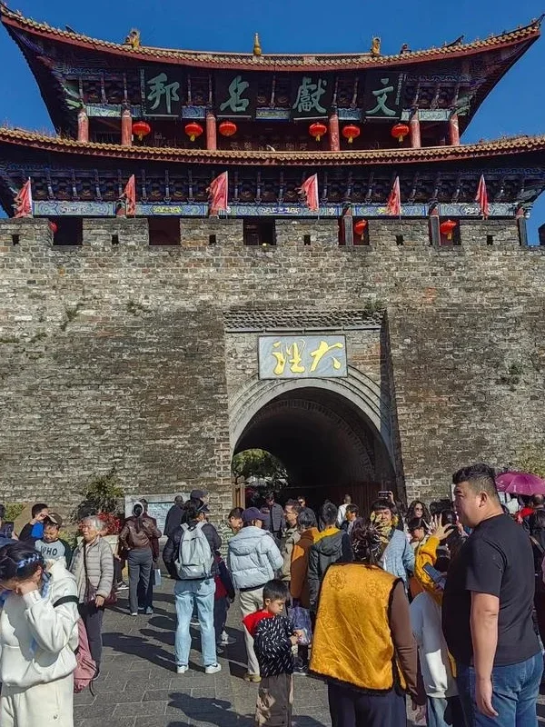 大理古城城門與文獻名邦城樓景觀,古老城牆與傳統樓閣建築高聳矗立,城門前遊客來往熱鬧,展現雲南大理古城歷史文化氛圍與著名旅遊地標景觀。