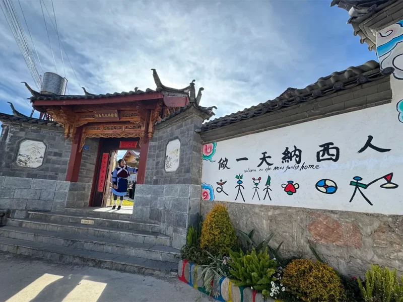 麗江納西族村落入口,傳統建築與文化圖騰裝飾。