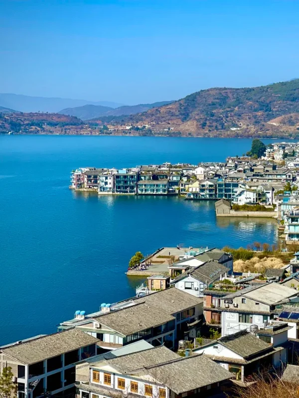 藍天碧水映襯下的 雙廊古鎮,湖岸建築錯落有致,展現靜謐悠閒風光。