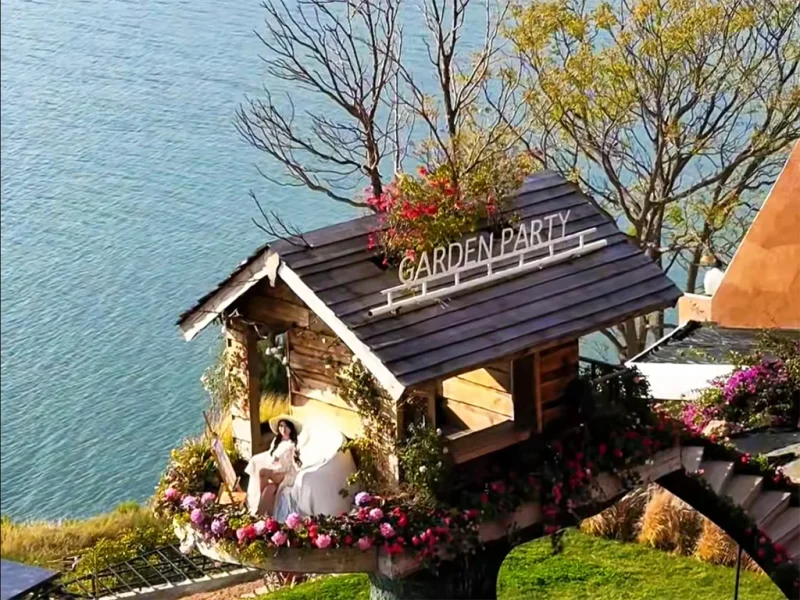大理洱海小木屋慢生活場景,湖畔木屋環繞花卉,一人悠閒享受寧靜時光。