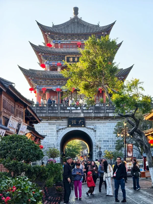 大理古城五華樓,傳統建築與紅燈籠點綴,下方為熱鬧街景與城門入口。